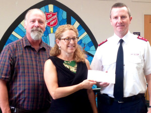 Julie Lapham, ENH Power Community Outreach Coordinator, presents a check to Rick Marshall (L) and Herb Rader (R) of the Salvation Army of Manchester.   