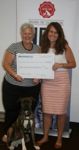 Norrie Crocker-Electricity Maine Community Outreach Coordinator (L) presents a check to Jeana Roth, Community Relations Manager, Animal Refuge League of Greater Portland.  Their 4 legged friend is Emma, a recent addition to Norrie's family.